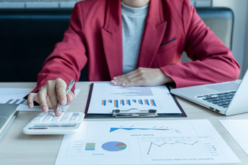 business man is sitting at a desk and calculating financial graph that show results