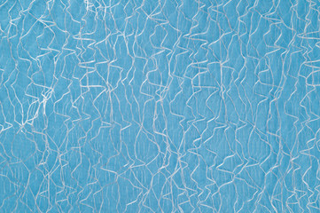 Guipure lying on a colored cloth, photographed close-up. Background for the texture of outerwear and fashion.