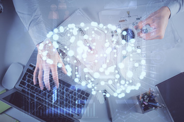 Double exposure of man's hands typing over computer keyboard and brain hologram drawing. Top view. Ai and data technology concept.