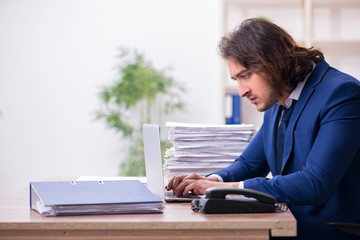 Young male employee unhappy with excessive work