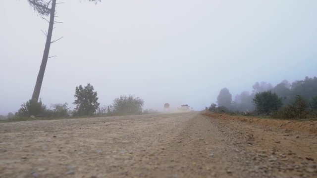 Truck Drives Into Mist On An Old Country Dirt Road Early In The Morning