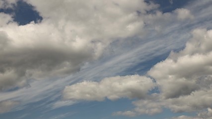 Clear blue sky with cumulus clouds that stand still and cirrus clouds that float. Joyful mood. High pressure and difference in movement in the atmosphere. Ecology of clean air. Weather forecast