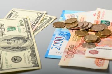 Cash banknotes and coins background. The background of the American and Russian money banknotes and coins. Dollars and rubles background.