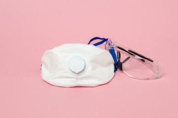 Coronavirus protection concept - medical face masks and glasses on pink background.