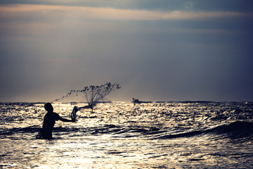 Fisherman on the beach at sunset in Bali