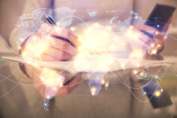Double exposure of business theme sketch hologram and woman holding and using a mobile device.