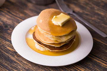 Golden pancakes with butter and warm maple syrup.