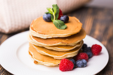 Homemade american pancakes with fresh blueberry and raspberries. Healthy morning breakfast. Rustic style