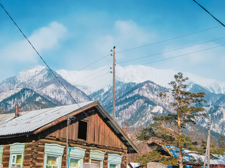Fototapeta na wymiar Village at the foot of the mountains in winter, winter background
