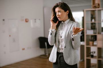 Businesswoman talking to the phone. Happy young woman working in office.	