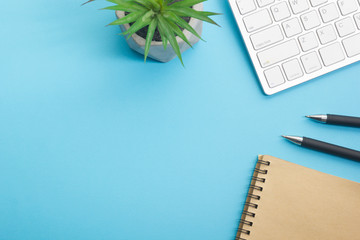 Blue desk office with laptop, smartphone and other work supplies with cup of coffee. Top view with copy space for input the text. Designer workspace on desk table essential elements on flat lay