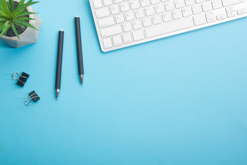 Blue desk office with laptop, smartphone and other work supplies with cup of coffee. Top view with copy space for input the text. Designer workspace on desk table essential elements on flat lay