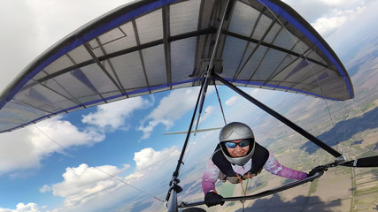 Female hangglider pilot high in the sky