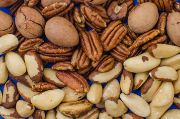 Pekan and brazil nuts on blue background. Healthy food