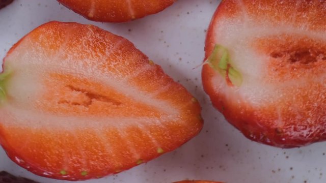 beautiful ripe strawberry close-up,sliced strawberry rotating,fruit macroshooting,healthy food and diet concept,source of vitamins,isolated half strawberry on white background rotates
