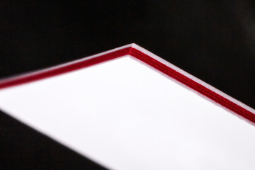 White and red three-ply thick stock business cards, floating on a black background, a mockup