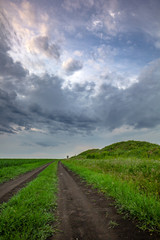 Road, hills and stormy sky