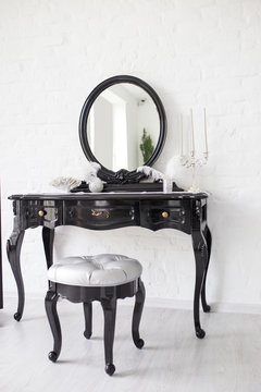 Black Boudoir Table In A Bright Room With A White Brick Wall.