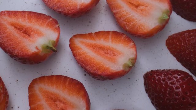 beautiful ripe strawberry close-up,sliced strawberry rotating,fruit macroshooting,healthy food and diet concept,source of vitamins,isolated half strawberry on white background rotates