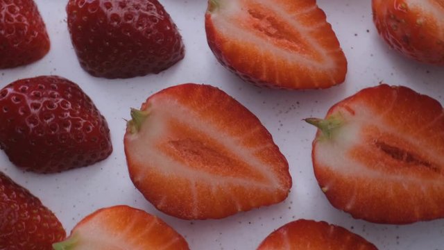 beautiful ripe strawberry close-up,sliced strawberry rotating,fruit macroshooting,healthy food and diet concept,source of vitamins,isolated half strawberry on white background rotates