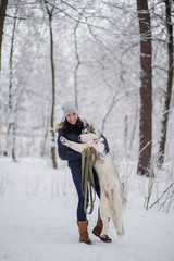 Fototapeta na wymiar woman with husky dog in winter in the snow