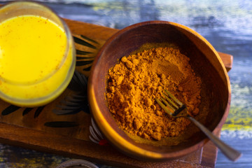 Golden milk powder and a glass of golden milk.