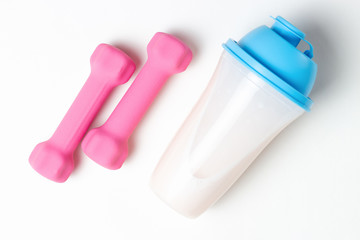 Shaker with protein and pink dumbbells on white background, top view, sports nutrition concept