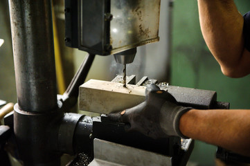 Worker drilling an aluminium block
