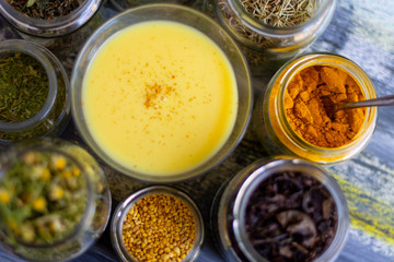 Golden milk powder and a glass of golden milk.