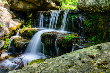 Fototapeta na wymiar Beautiful waterfall on small river in a park
