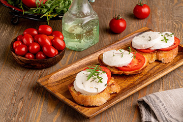 mozzarella with tomato slice on the toast on wooden board