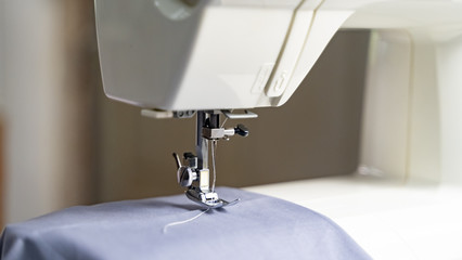 Electric sewing machine with fabric and thread