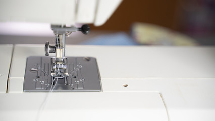 Electric sewing machine with fabric and thread
