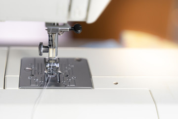 Electric sewing machine with fabric and thread