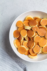 Pancake cereal with butter in a white bowl. Breakfast food concept.