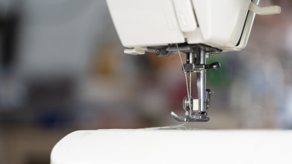 Electric sewing machine with fabric and thread