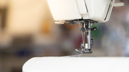 Electric sewing machine with fabric and thread