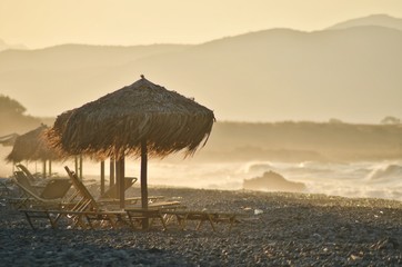 Grass beach umbrellas sunset in Greece