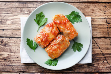 Cabbage rolls with beef, rice and vegetables on the plate. Stuffed cabbage leaves with meat. Wooden background Copy space.