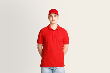 Modern post and package delivery. Courier in red uniform on light background