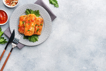 Cabbage rolls with beef, rice and vegetables on the plate. Stuffed cabbage leaves with meat. Gray concrete table Copy space.