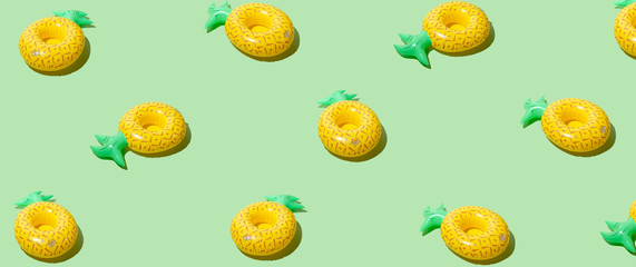 Yellow inflatable pineapples on a green background