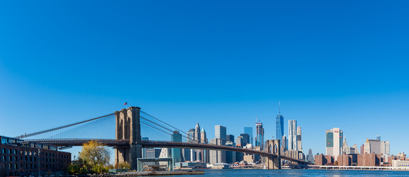 Fototapeta Wide panorama of skyscrapers in Manhattan with Brooklyn Bridge, New York at daytime