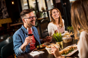 Group of young people having dinner in the restaurant