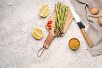 Asparagus with eggs, lemon and spices on grey background