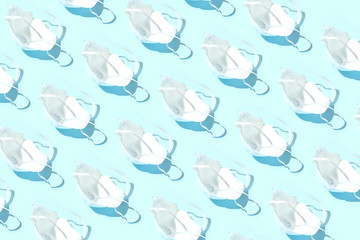 Fototapeta premium Many medical masks on the blue colored background to cover the mouth and nose for protection from virus and bacteria on a blue background.