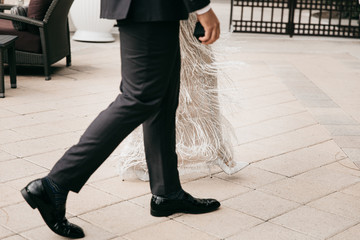 Bride and groom are walking on the street. Groom hold the engagement ring box