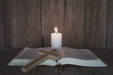 The crucifix rested on the Bible. While there are candles that illuminate Christian religious...