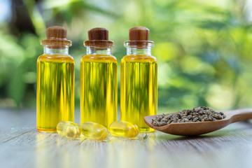 CBD hemp oil is lined up in a wooden spoon and extracted tablets. Hemp tree background Medical marijuana concepts in the treatment of diseases Herbs that use oil in therapy Alternative medicine.