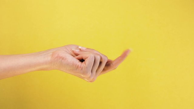 Beckoning sign. Come here. Single handed gesture. closeup. Isolated on yellow background